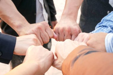 Toplantının simgesi olan kurumsal toplantılarda çalışan yedi kişinin el kaldırması takım çalışması kalitesine ve etkin personele katılması takım çalışması ve iş dünyasındaki organizasyonel gelişimi kavramına katılıyor.