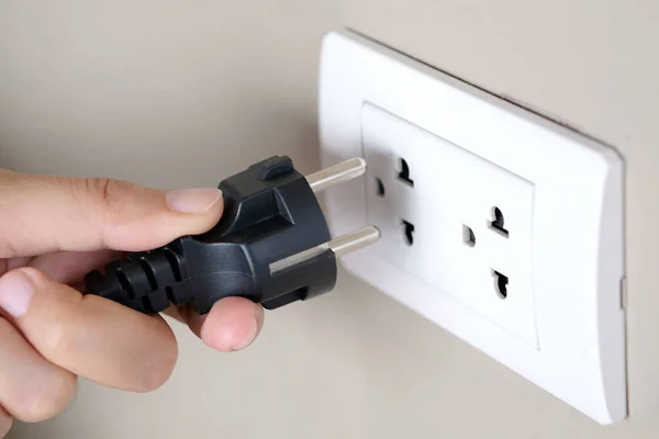 Elektrik Cihazları 'nın Eli fişi çekiyordu. Fişi çek. Çalışma saatlerinde ofisinde. Enerji Tasarruf Kavramları ve Teknolojileri