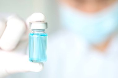 Doktor eli, elinde bir şişe antiretroviral ilaç tutuyor, mavi su. Sağlık ve tıbbi kavramlar
