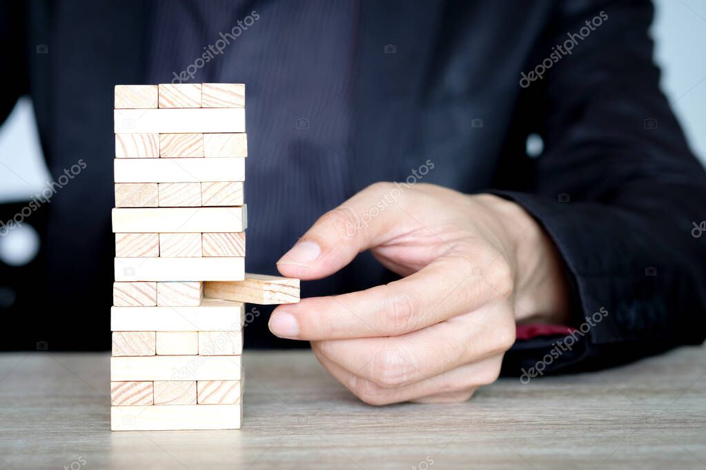 Steps of success for business or investment. Business man is arranging wood block to increase high, Business concept , Investment concept of successful.
