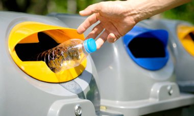 Lütfen plastik şişeyi depoya atın. Bir adam çöp tenekesine çöp atar gibi çöp atmak için çöpleri ayırır. ,