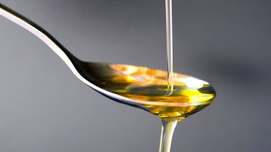 Pouring olive oil in the a spoon at kitchen. Prepare for cooking concept. Healthcare and Beauty Concept.