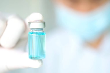 Doktor eli, elinde bir şişe antiretroviral ilaç tutuyor, mavi su. Sağlık ve tıbbi kavramlar