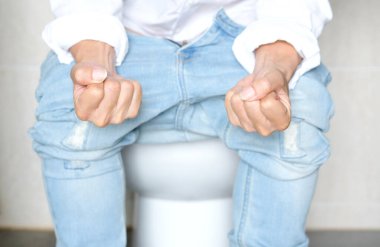 Tuvalette oturan adam. Banyoda, evi kabızlık, ishal, gıda zehirlenmesi, sağlık ve tıbbi kavramlardan memnun değil..