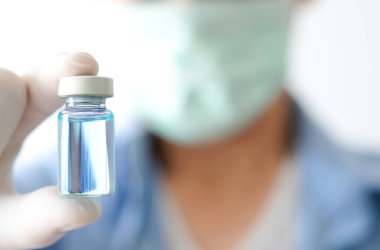 Doktor eli, elinde bir şişe antiretroviral ilaç tutuyor, mavi su. Sağlık ve tıbbi kavramlar
