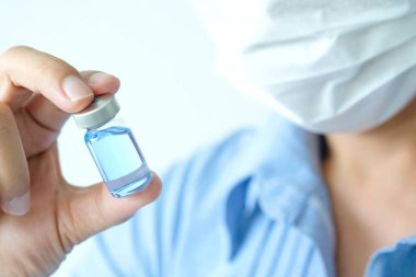 Doktor eli, elinde bir şişe antiretroviral ilaç tutuyor, mavi su. Sağlık ve tıbbi kavramlar