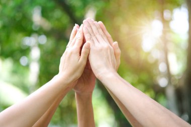 Toplantının simgesi olan kurumsal toplantılarda çalışan yedi kişinin el kaldırması takım çalışması kalitesine ve etkin personele katılması takım çalışması ve iş dünyasındaki organizasyonel gelişimi kavramına katılıyor.