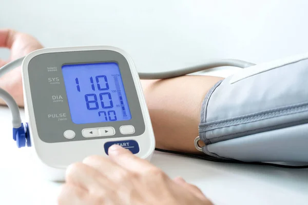 血圧計で血圧モニターと心拍数モニターをチェックしてる ヘルスケアと医療の概念 — ストック写真