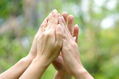 Toplantının simgesi olan kurumsal toplantılarda çalışan yedi kişinin el kaldırması takım çalışması kalitesine ve etkin personele katılması takım çalışması ve iş dünyasındaki organizasyonel gelişimi kavramına katılıyor.