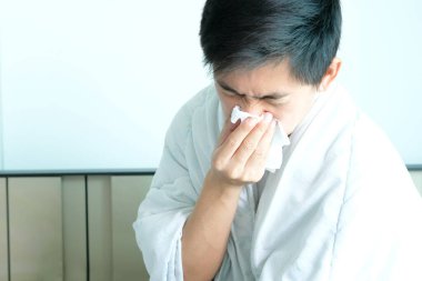 Hasta adam grip, kağıt peçete kullanıyor ve burnu akıyor. Ve üzerinde kalın giysiler vardı. Sağlık konsepti.