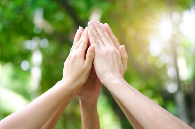 Toplantının simgesi olan kurumsal toplantılarda çalışan yedi kişinin el kaldırması takım çalışması kalitesine ve etkin personele katılması takım çalışması ve iş dünyasındaki organizasyonel gelişimi kavramına katılıyor.