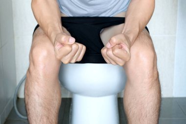 Tuvalette oturan adam. Banyoda, evi kabızlık, ishal, gıda zehirlenmesi, sağlık ve tıbbi kavramlardan memnun değil..