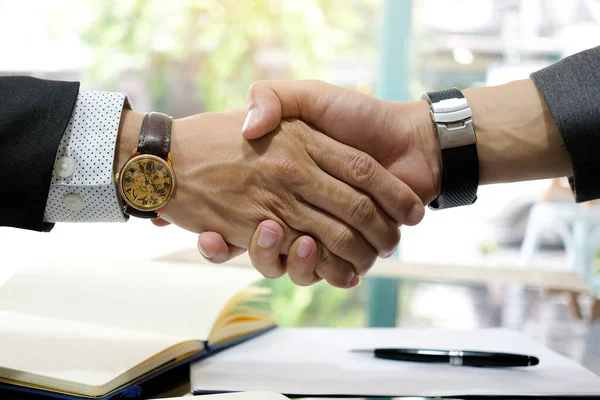 Hand of people shake hand make a deal on a business together in his office.working assemble corporate meeting show symbol join forces teamwork quality and effective personnel Concept organizational