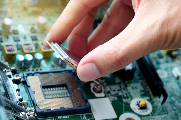 Рука компьютерной инженерии приносит компоненты памяти процессора CPU в сокет-процессор для обслуживания.
