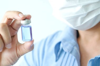 Doktor eli, elinde bir şişe antiretroviral ilaç tutuyor, mavi su. Sağlık ve tıbbi kavramlar