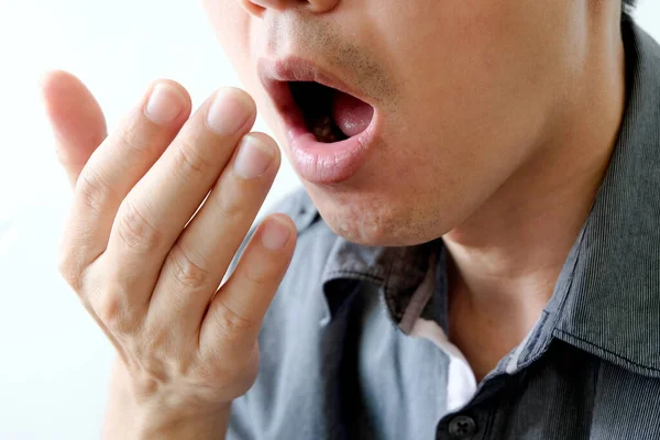 Oral health Men use hands to check for bad breath and breathe.