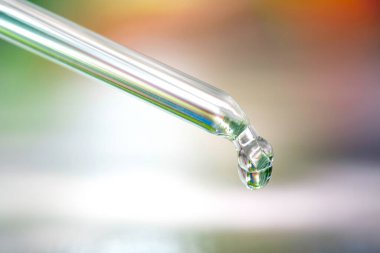 Yüz fonundan serum kolajen nemlendirici dökülüyor. Koruyucu cilt bakımı yüz özü yağı, C vitamini güzellik ve kaplıca konsepti.