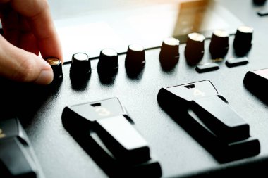 Adamın eli amplifikatörden müzik sesini ayarlıyor..