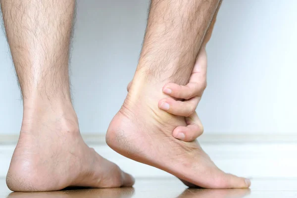 Picture of a male leg And the man\'s hand, he caught his ankle Pain in the ankle