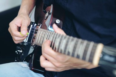 Genç adam eğlenceli bir elektro gitar çalar.