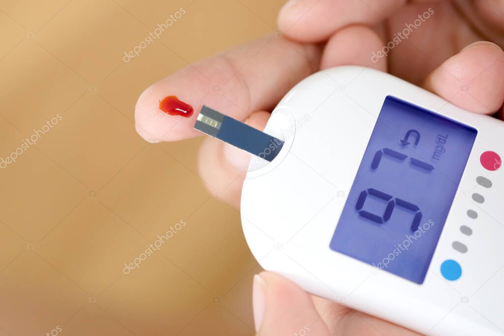 hand of people check diabetes and high blood glucose monitor with digital pressure gauge. Healthcare and Medical concept