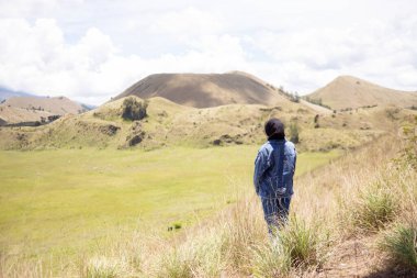 Genç Asyalı sırt çantalı kız mutlu ve Wurung Krateri 'nde (Kawah Wurung).