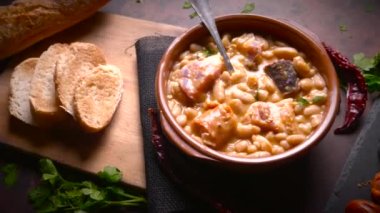 Geleneksel fasulye tarifi sucuklu ve kanlı sosis Fabada Asturiana adında karanlık bir masa üzerinde bazı malzemelerle birlikte. Tipik İspanyol yemekleri.. 