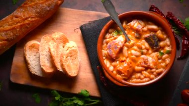 Geleneksel fasulye tarifi sucuklu ve kanlı sosis Fabada Asturiana adında karanlık bir masa üzerinde bazı malzemelerle birlikte. Tipik İspanyol yemekleri.. 