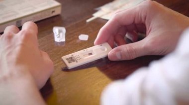 Caucasian white man waiting for the result of a covid antigen self at home. The result is positive. He is infected. Collapses on the table.