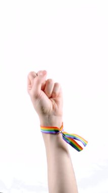 El, orta parmağı protesto sembolü olarak gösteren LGBT bayrağı renginde bir bilezik takıyordu. LGBT sembolü. Dikey video.