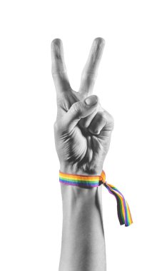 LGBT bayrağı renginde bir bilezik takan siyah ve beyaz el barış ya da zaferin sembolü olarak iki parmağını gösteriyor. LGBT sembolü.