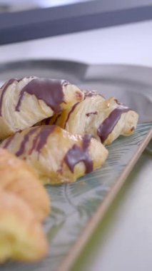 Chocolate bakery products called mini napolitana and croissants on a metal tray with coffee for breakfast. Sweet snack.
