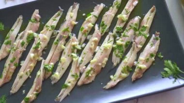 Üç tabak patates cipsi, ançüez ve yeşil zeytinleri maydanoz yapraklı beyaz ahşap bir masada topladım. Barda yemek için tipik İspanyol atıştırmalıkları..