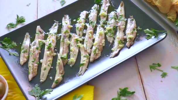 三道菜 马铃薯片 采摘的凤尾鱼和绿色橄榄在一个白色的木制桌子上与欧芹叶 在酒吧里吃的典型西班牙小吃 — 图库视频影像