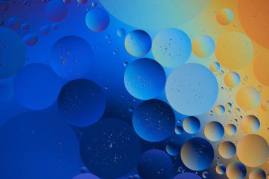 Su içinde mavi ve turuncu baloncuklu soyut arkaplan. Makro fotoğrafçılık. Üst görünüm.