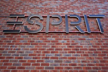 Metzingen, Almanya - 20 Mart 2021: Esprit siyah harfler kırmızı tuğla duvarda. Yukarı görünüm.