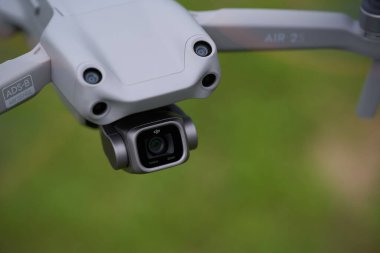 Nuertingen, Almanya - 26 Haziran 2021: Dji Air 2 'nin insansız hava aracı. Algılayıcıları ve 1 inçlik kamerası olan gri bir çoklu helikopter. Yeşil çayır alan derinliği. Yüksek açı görünümü.