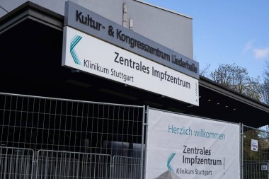 Stuttgart, Almanya - 3 Nisan 2021: Merkezi aşı merkezi (Zentrales Impfzentrum). Bilgi afişleri çelik çitlere asılmış. Yukarı bak. Almanya, Liederhalle.