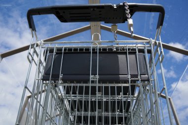 Camdan çatı altında alışveriş arabası. Bulutlu mavi gökyüzü. Düşük açı görünümü.