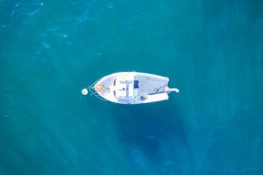 Atlantik 'ten gelen boş bir balıkçı teknesi. Mavi deniz suyundaki küçük beyaz geminin havadan görünüşü. Ayrı bir nesne. Fransa.