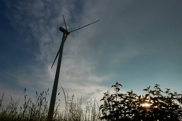 Windturbine Naast Een Donkere Stormwolk Ondergaande Zon Schijnt Door Brandnetels — Stockfoto