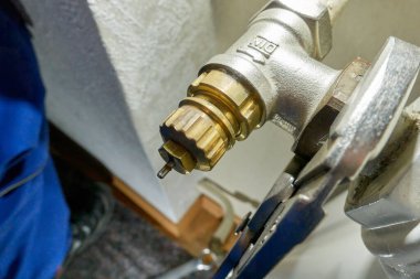 Eski danfoss radyatör termostat vanasını değiştir. Kerpeten ısıtıcıdan bileşenleri çıkarır. Isıtma sistemlerinin modernizasyonu. Üst görünüm.