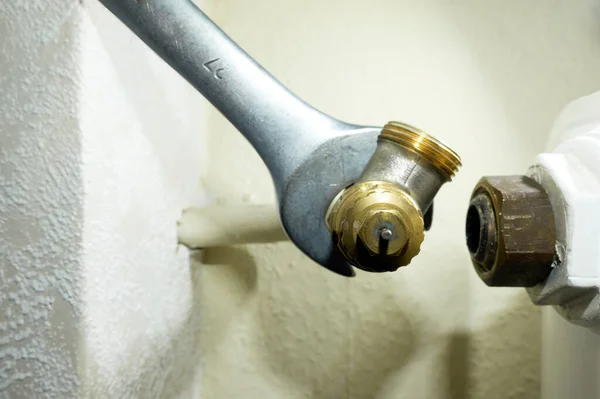 Eski radyatör termostat vanasını değiştir. Alet ısıtıcıdan bileşeni kaldırır. Isıtma sistemlerinin modernizasyonu. Ön görünüm.