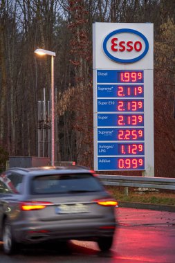Schonbuch, Almanya - 25 Şubat 2022: Pahalı benzin ve dizel fiyatları etiketi. Avrupa, Almanya 'daki esso benzin istasyonlarında yakıt ikmali. Gri araba hareket halinde.