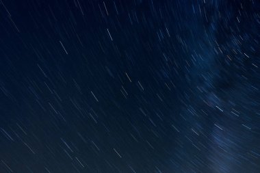 Karanlık gece gökyüzünde yıldız izleri. Uzun pozlama, hareket bulanık.