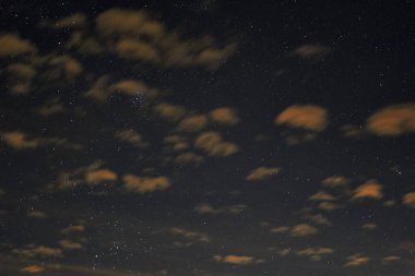 Turuncu bulutların arkasında gece yıldızlı gökyüzü. Desen.