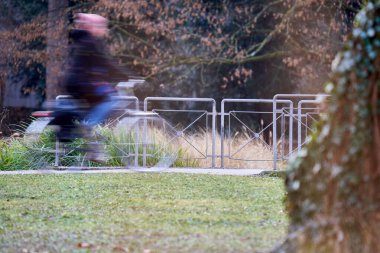 Bisiklet yolu. Parkta bir kadın bisikletçi. Kadın hareketi bulanıklaştı. Egzersiz ile sağlıklı bir yaşam tarzı. Almanya, Stuttgart, Schlossgarten.