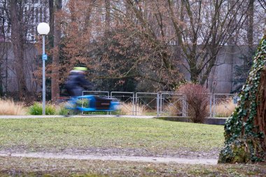 Bisiklet yolu. Parkta bir erkek bisikletçi. İnsan hareketi bulanıklaştı. Egzersiz ile sağlıklı bir yaşam tarzı. Almanya, Stuttgart, Schlossgarten.