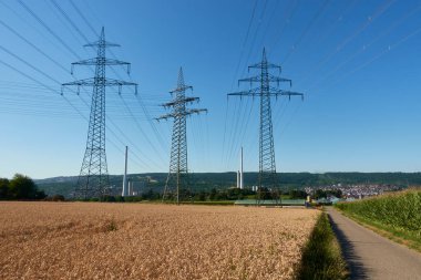 Kömür santrali devre dışı. Elektrik direkleri ve buğday tarlasıyla manzara. Kömür enerjisinden çıkış. Almanya, Deizisau, Altbach.