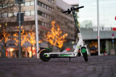 Stuttgart, Germany - December 31, 2021: One E Scooter in the Christmas decorated city street. Vehicle for local transport on cobblestones.